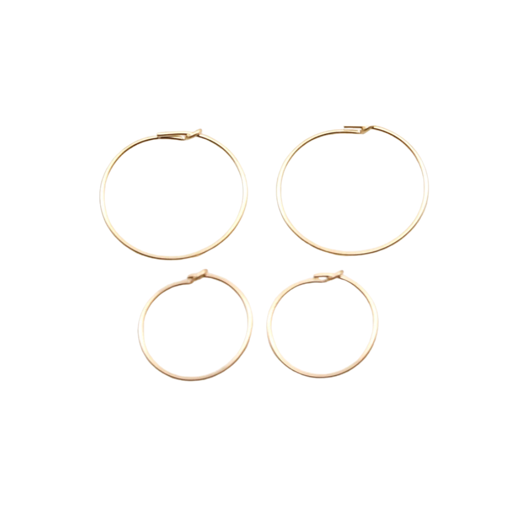 Four gold hoop earrings on a white background