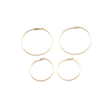 Four gold hoop earrings on a white background
