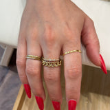 A person's hand showcasing a gold infinity chain ring custom made by Golden Bond Jewelry. The woman has red nail polish on.