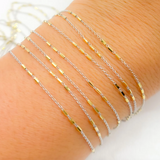 Cosmo is 3 gold bars on white gold bracelet chain